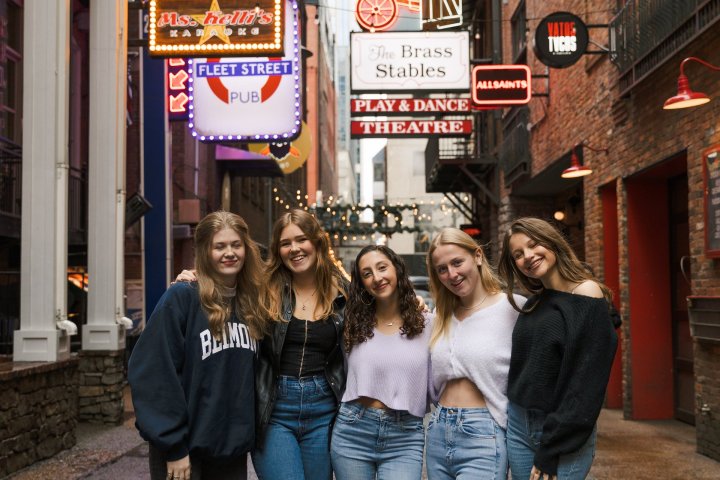 a group of people walking down a street next to a sign