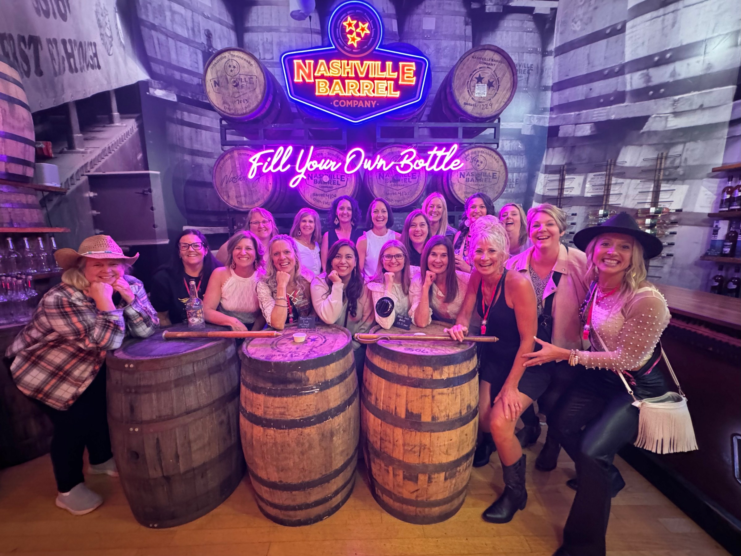 a group of pretty girls in front of nashville whiskey barrels store