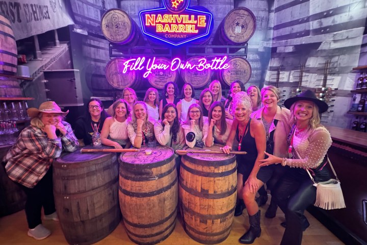 a group of pretty girls in front of nashville whiskey barrels store