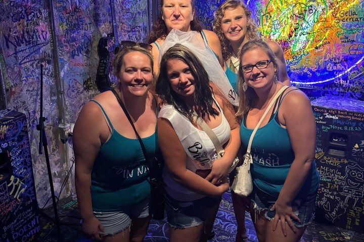 a woman standing in front of a group of people posing for the camera