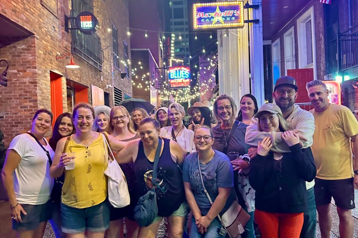 a group of people that are standing in printers alley at night