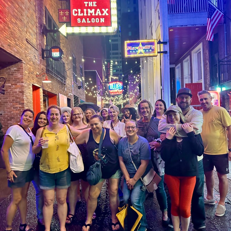 a group of people that are standing in printers alley at night