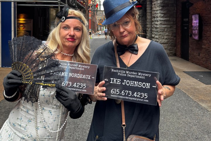 a person holding a sign posing for the camera