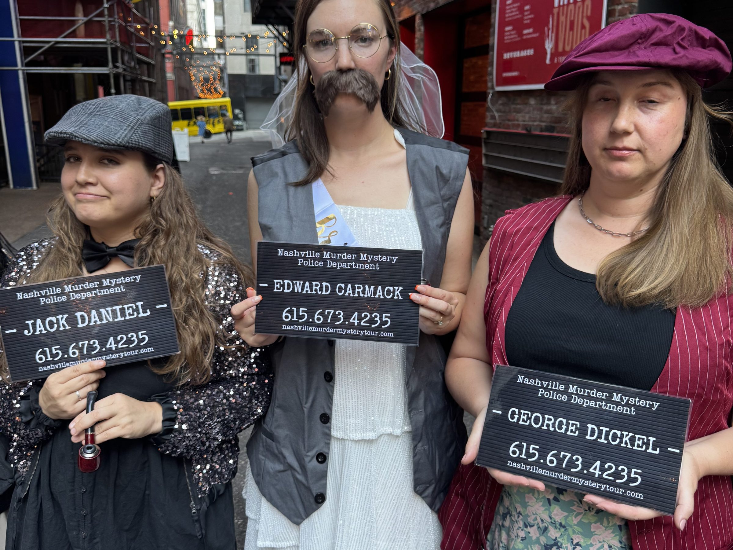 a group of murder mystery tour people posing in printer's alley nashville