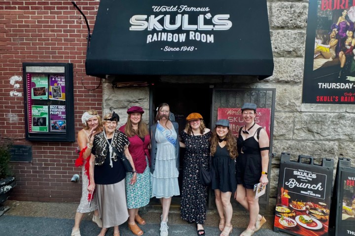 a group of people standing in front of a sign